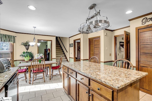 kitchen featuring a center island, decorative light fixtures, ornamental molding, light tile patterned floors, and light stone counters