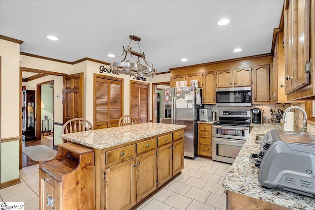 kitchen featuring ornamental molding, a sink, a kitchen island, stainless steel appliances, and light tile patterned floors