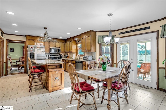 dining space featuring crown molding, light tile patterned floors, visible vents, and a chandelier