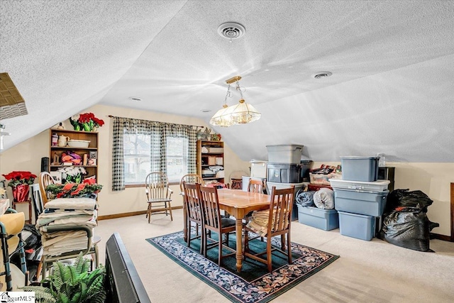 dining area with visible vents, a textured ceiling, carpet flooring, baseboards, and vaulted ceiling