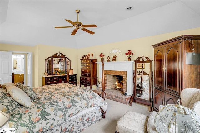 carpeted bedroom featuring visible vents, lofted ceiling, a ceiling fan, and a fireplace