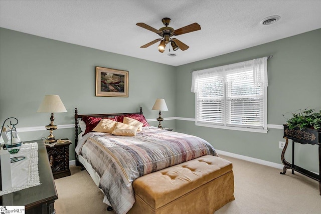 bedroom with visible vents, baseboards, light carpet, a textured ceiling, and a ceiling fan