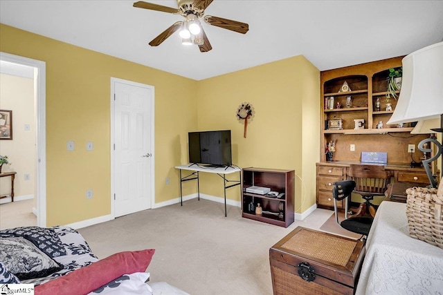 living area featuring a ceiling fan, baseboards, and light carpet