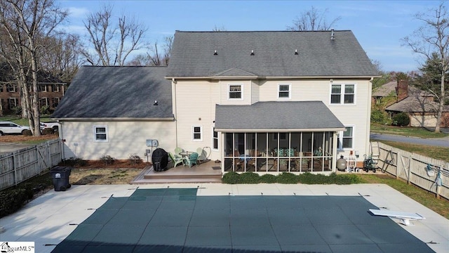 rear view of house featuring a fenced in pool, a sunroom, a deck, a fenced backyard, and a patio area