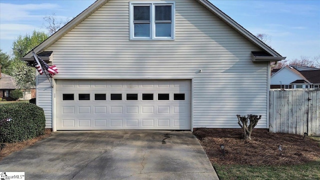 view of property exterior with a garage, driveway, and fence