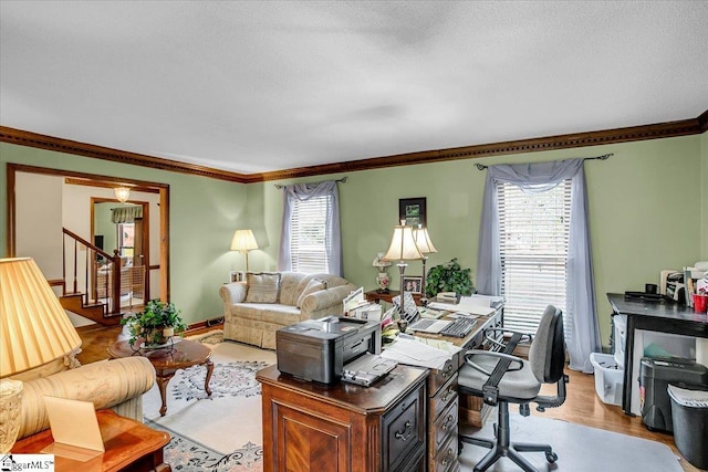 office with light wood-style floors, a healthy amount of sunlight, crown molding, and a textured ceiling