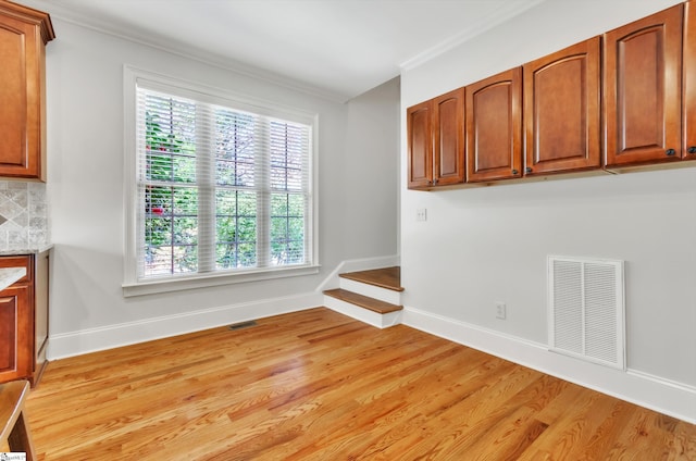 unfurnished dining area with light wood finished floors, visible vents, and a healthy amount of sunlight