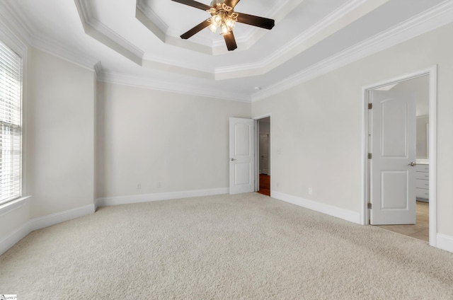 empty room with light carpet, crown molding, and a tray ceiling