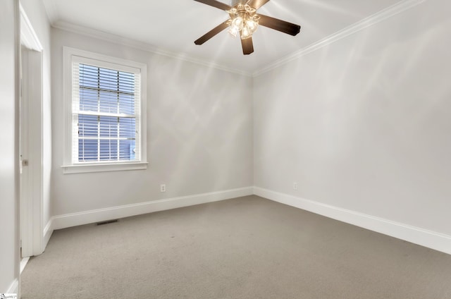 spare room featuring carpet, visible vents, baseboards, ceiling fan, and crown molding