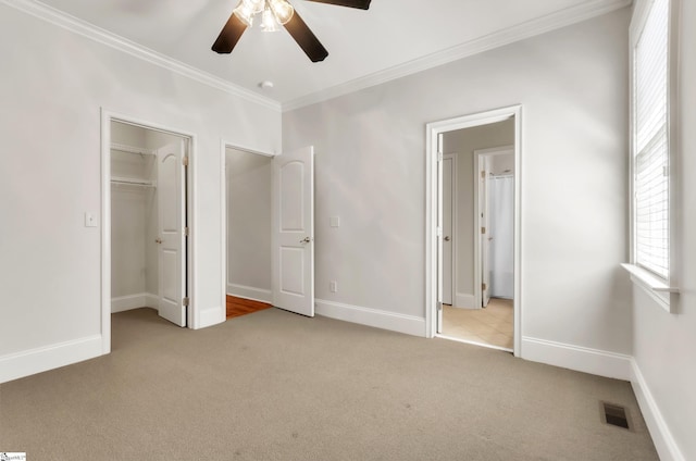 unfurnished bedroom featuring visible vents, baseboards, carpet, and crown molding