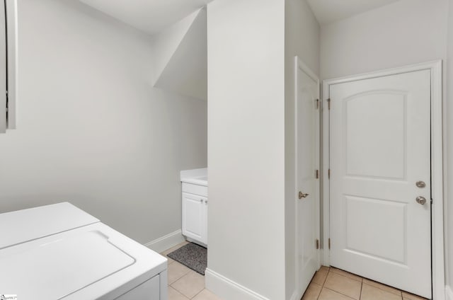 washroom with light tile patterned floors, cabinet space, baseboards, and washer and clothes dryer