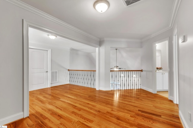 spare room with visible vents, ornamental molding, ceiling fan, and wood finished floors