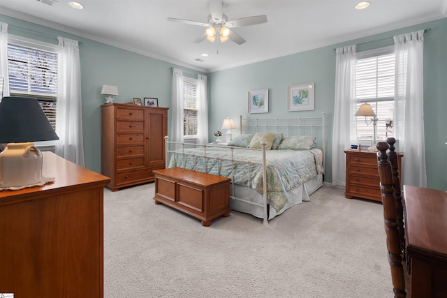 bedroom with recessed lighting, light colored carpet, multiple windows, and ornamental molding