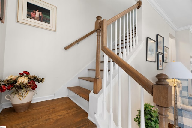 stairs featuring wood finished floors, baseboards, and ornamental molding