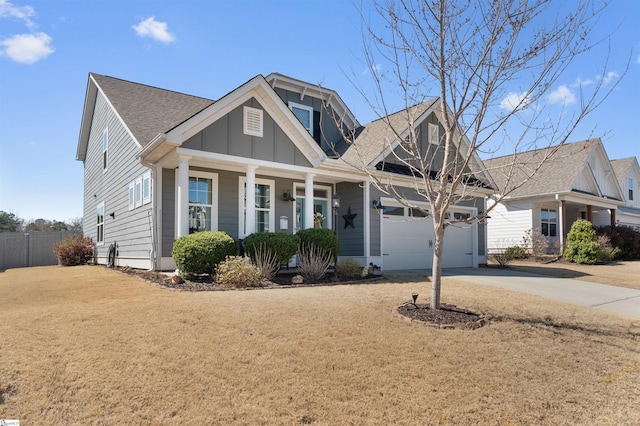 view of front of home featuring driveway, a porch, fence, board and batten siding, and a garage