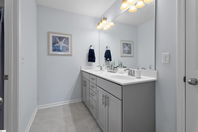 full bathroom with double vanity, baseboards, tile patterned floors, and a sink