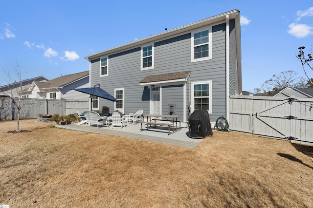 back of house with a yard, a patio, fence, and a gate