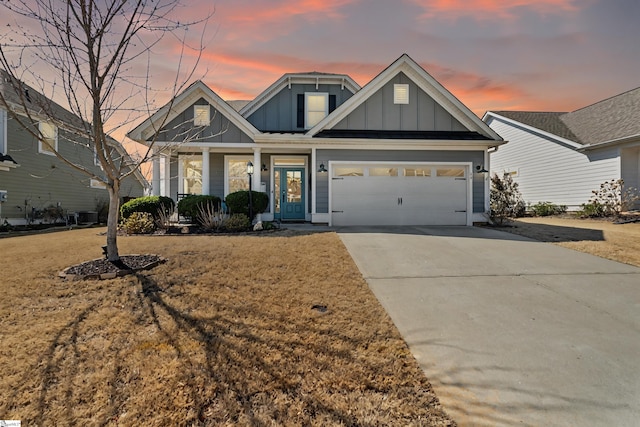 craftsman inspired home with concrete driveway, a porch, a lawn, and board and batten siding