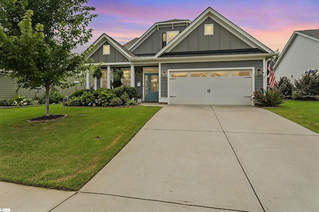 craftsman-style house featuring a garage, driveway, board and batten siding, and a front lawn