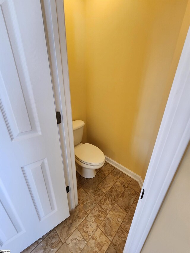 bathroom featuring toilet and baseboards
