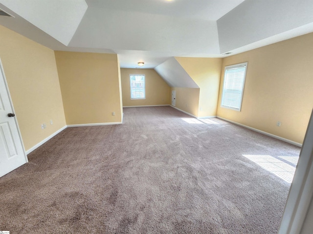additional living space featuring visible vents, vaulted ceiling, baseboards, and carpet
