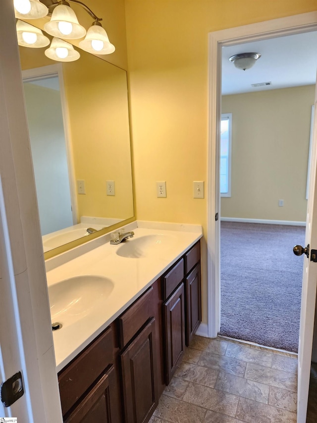 bathroom with baseboards, a sink, and visible vents