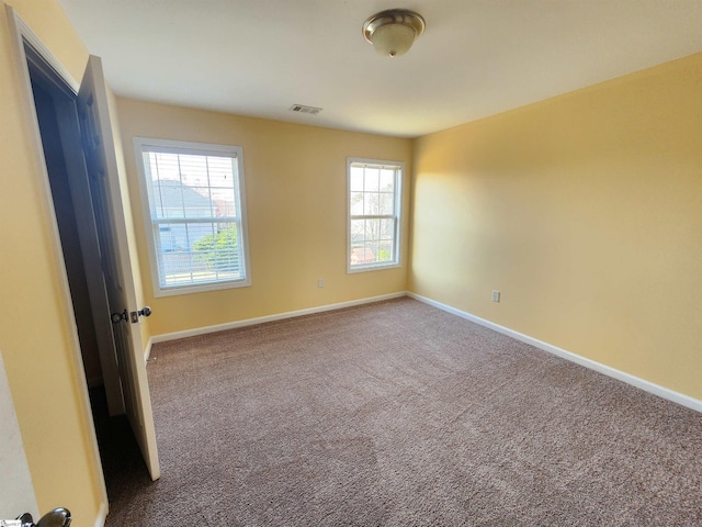 carpeted empty room with baseboards and visible vents
