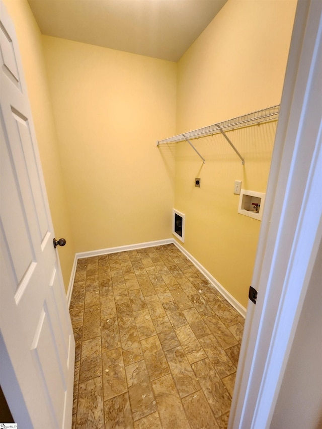 laundry room with laundry area, stone finish flooring, hookup for a washing machine, baseboards, and electric dryer hookup