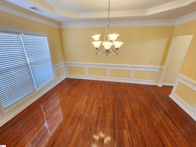 unfurnished room featuring a tray ceiling, visible vents, a notable chandelier, wood finished floors, and crown molding