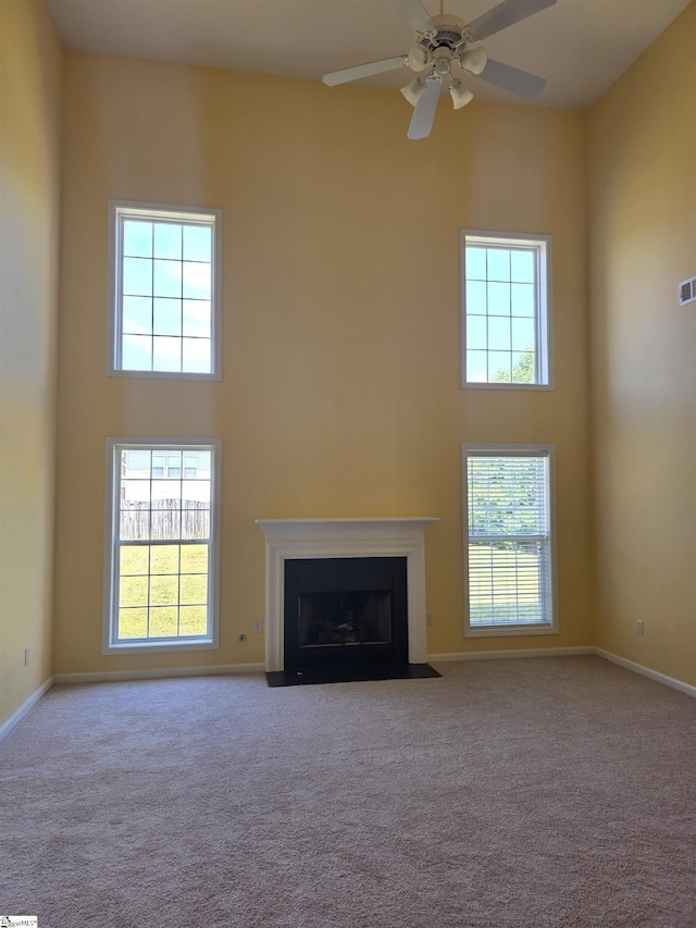 unfurnished living room with a towering ceiling and a healthy amount of sunlight