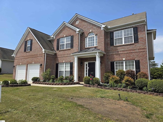 traditional-style home with brick siding, an attached garage, and a front lawn