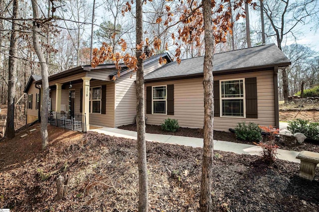 ranch-style house with a porch and a shingled roof