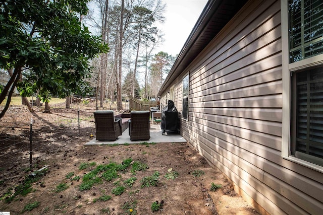 view of side of property featuring a patio and fence