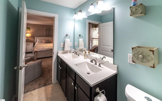 bathroom featuring a sink, toilet, double vanity, and ensuite bathroom