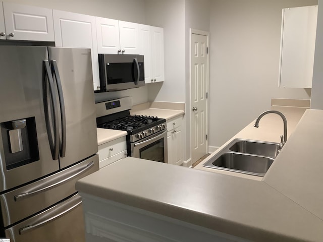 kitchen with a sink, light countertops, white cabinetry, and stainless steel appliances