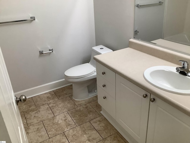 bathroom featuring baseboards, toilet, and vanity