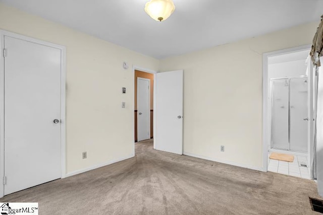 unfurnished bedroom with carpet flooring, visible vents, ensuite bathroom, and baseboards