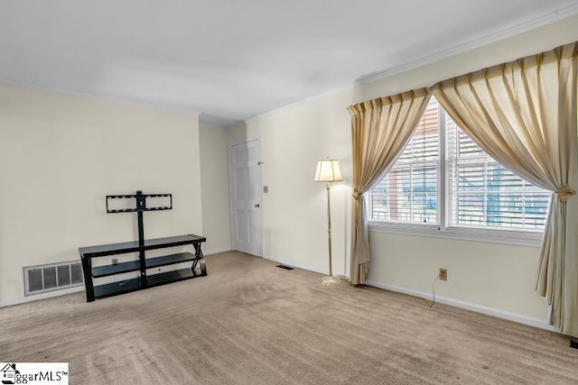 carpeted empty room featuring crown molding, baseboards, and visible vents