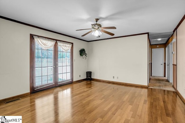 empty room with light wood-type flooring, visible vents, ceiling fan, and crown molding