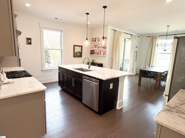 kitchen featuring dark wood finished floors, appliances with stainless steel finishes, light stone counters, and a sink