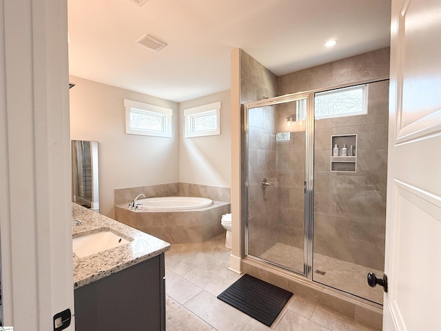 bathroom featuring plenty of natural light, a garden tub, and a shower stall