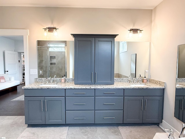 full bath with double vanity, a tile shower, and a sink