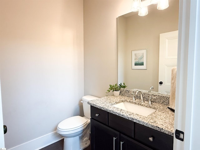 bathroom with vanity, toilet, and baseboards