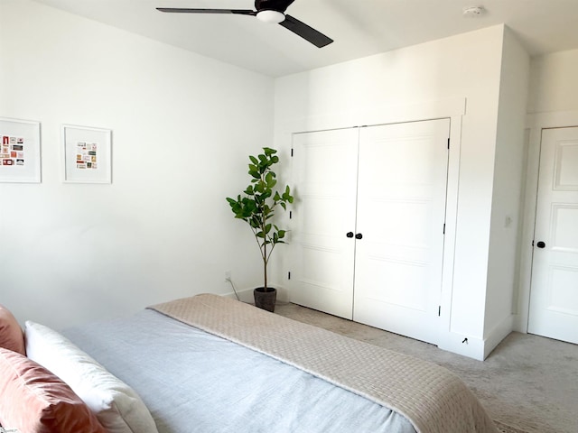 bedroom with a closet, light colored carpet, and ceiling fan