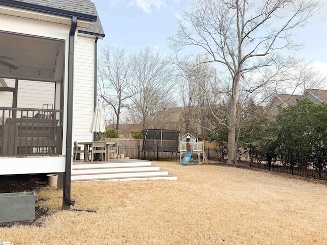 view of yard featuring a playground, a fenced backyard, and a wooden deck