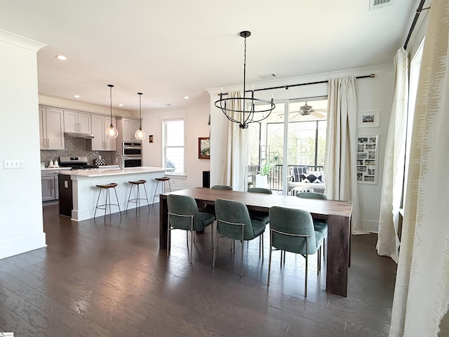 dining space featuring dark wood finished floors, visible vents, recessed lighting, and crown molding