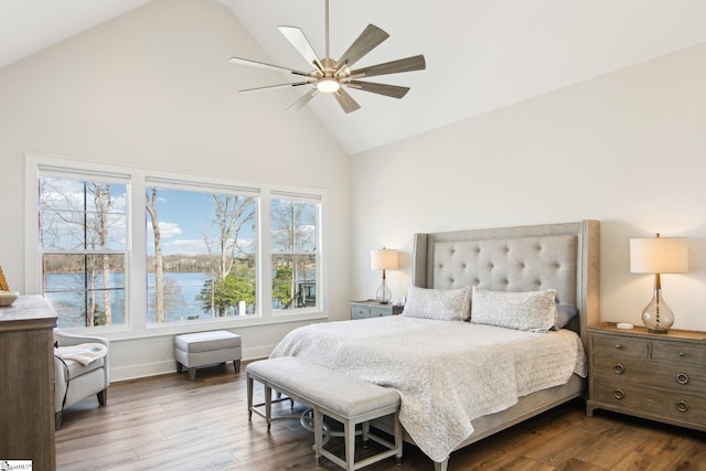 bedroom featuring high vaulted ceiling, a water view, a ceiling fan, and wood finished floors