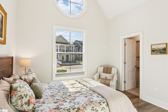 bedroom with wood finished floors, baseboards, and vaulted ceiling