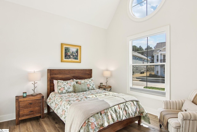 bedroom featuring vaulted ceiling, wood finished floors, and baseboards