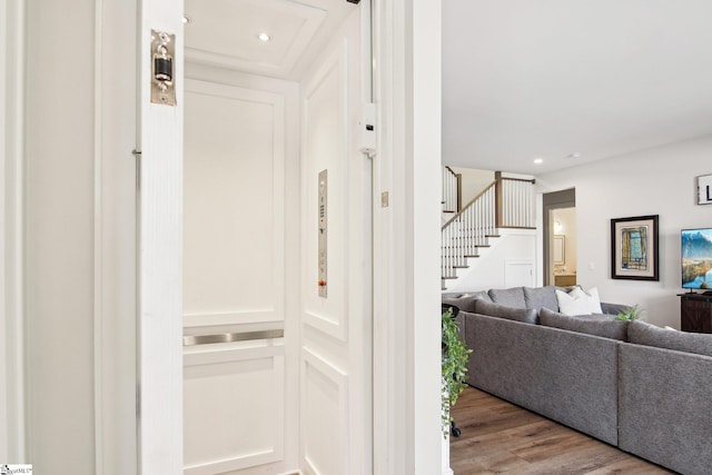 interior space with elevator, stairway, recessed lighting, and wood finished floors